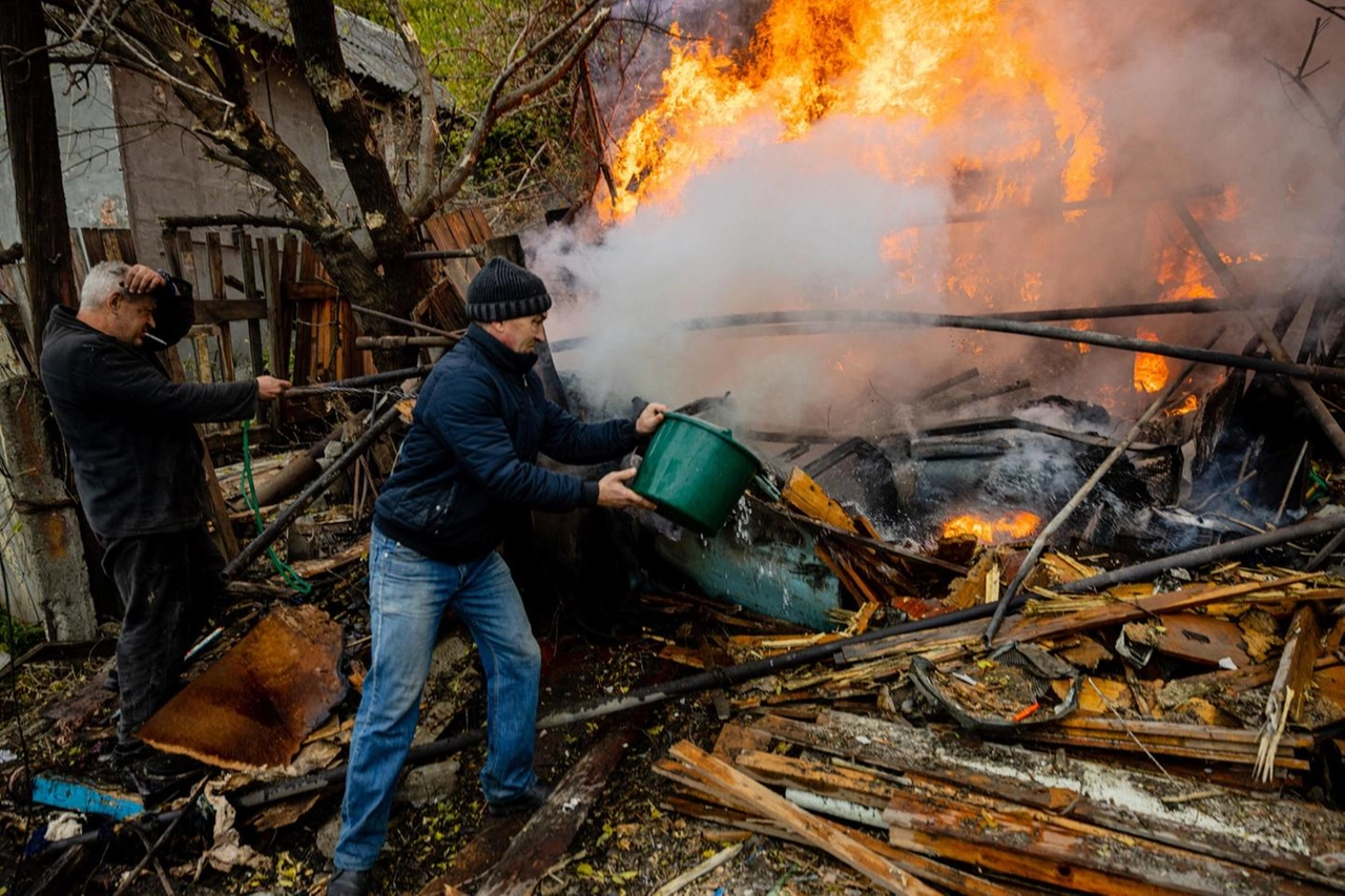 Residenti locali estinguono del fuoco a Bakhmut (Afp)