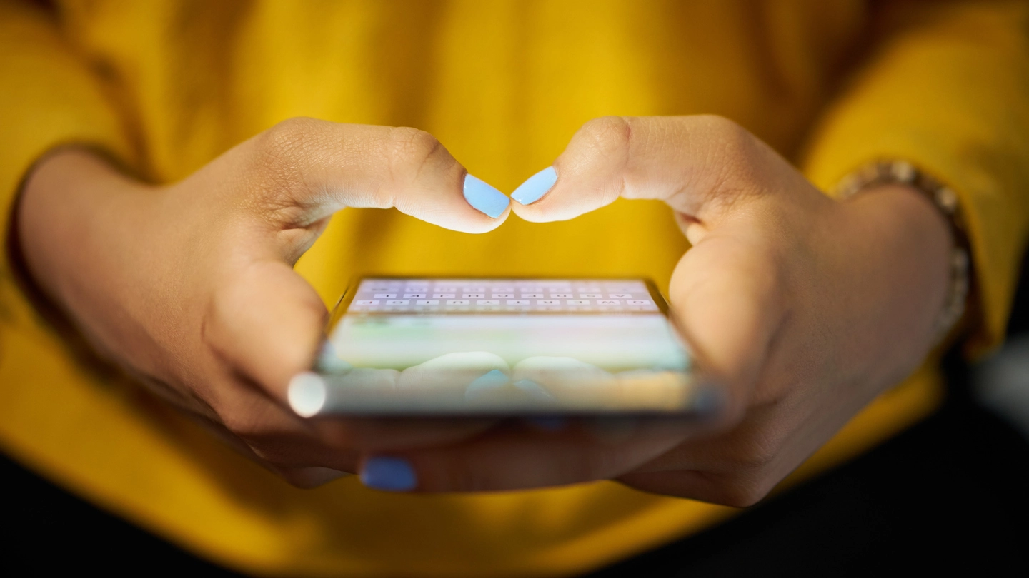 Una ragazza al cellulare (foto iStock)