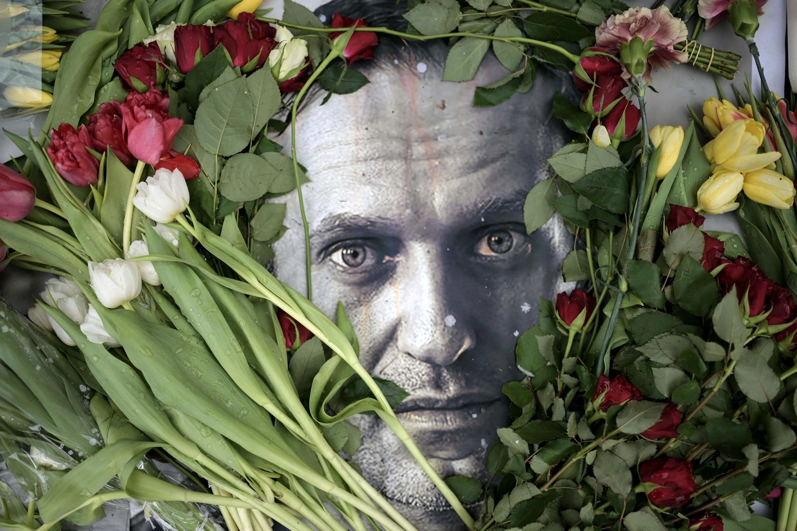 Fiori attorno a un ritratto di Navalny (Ansa)