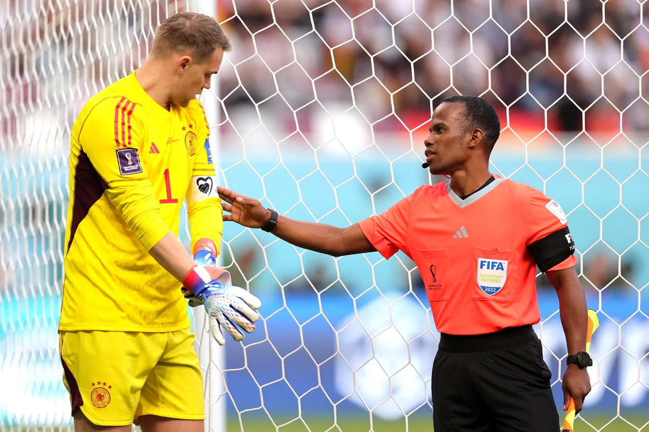 Un guardalinee controlla la fascia di Neuer prima della partita contro il Giappone (Epa)