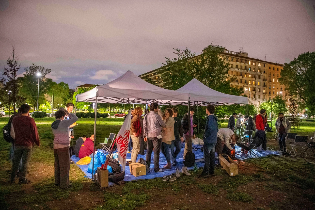 Studenti accampati fuori dal Politecnico di Milano riuniti sotto i gazebo installati per ripararsi dalle intemperie (Ansa)