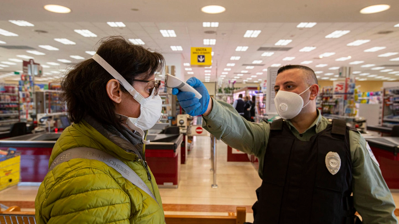 Misurazione della temperatura prima di entrare in un supermercato (Ansa)