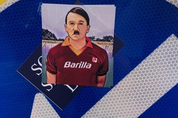 Uno degli adesivi raffiguranti Hitler con la maglia della Roma apparsi nella Capitale