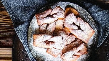 INGREDIENTI E DOSI 500 g di farina, 100 g di strutto, 2 uova, 3 cucchiai di zucchero, lievito per dolci, 300 g di castagne lessate e passate, 100 g di cacao dolce in polvere, 1/2 bicchiere di saba, zucchero q.b, marmellata di albicocche, buccia grattugiata di un'arancia