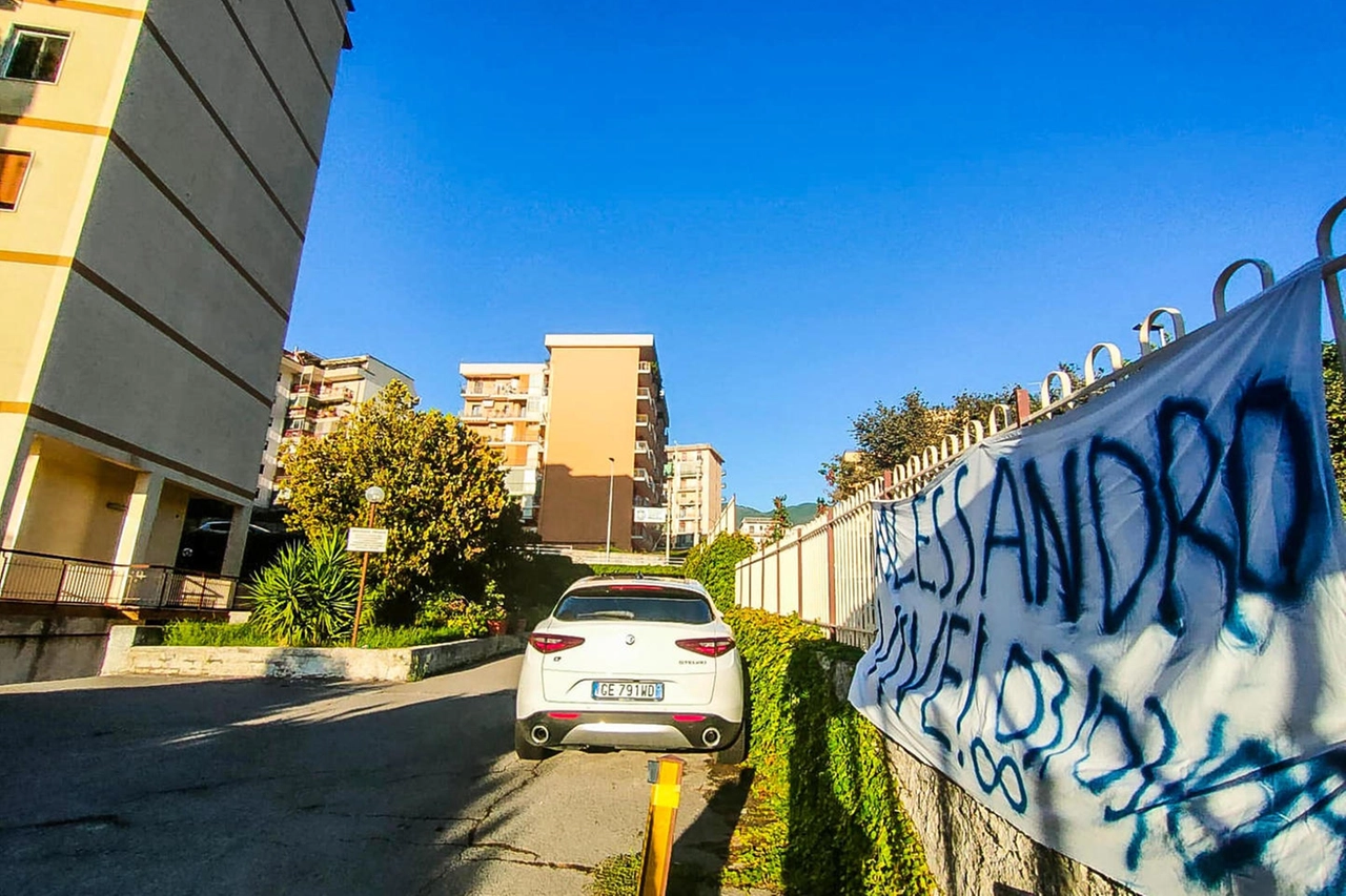 Lo striscione per Alessandro davanti al palazzo della tragedia