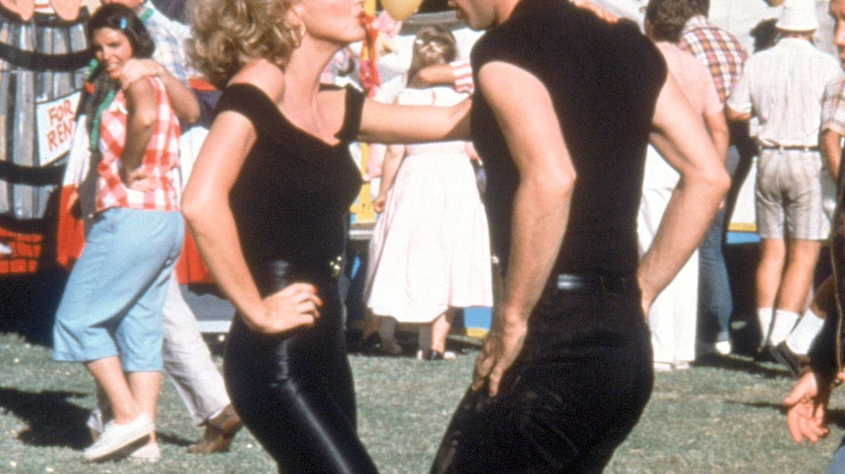 Una delle scene cult di ’Grease’; in alto a destra, Olivia Newton-John, 71 anni, oggi