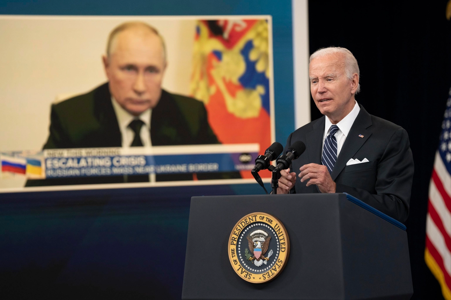Il presidente Joe Biden, sullo sfondo Vladimir Putin