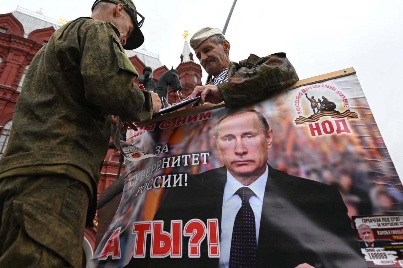 Sostenitori di Putin tengono un suo ritratto nella piazza Rossa di Mosca