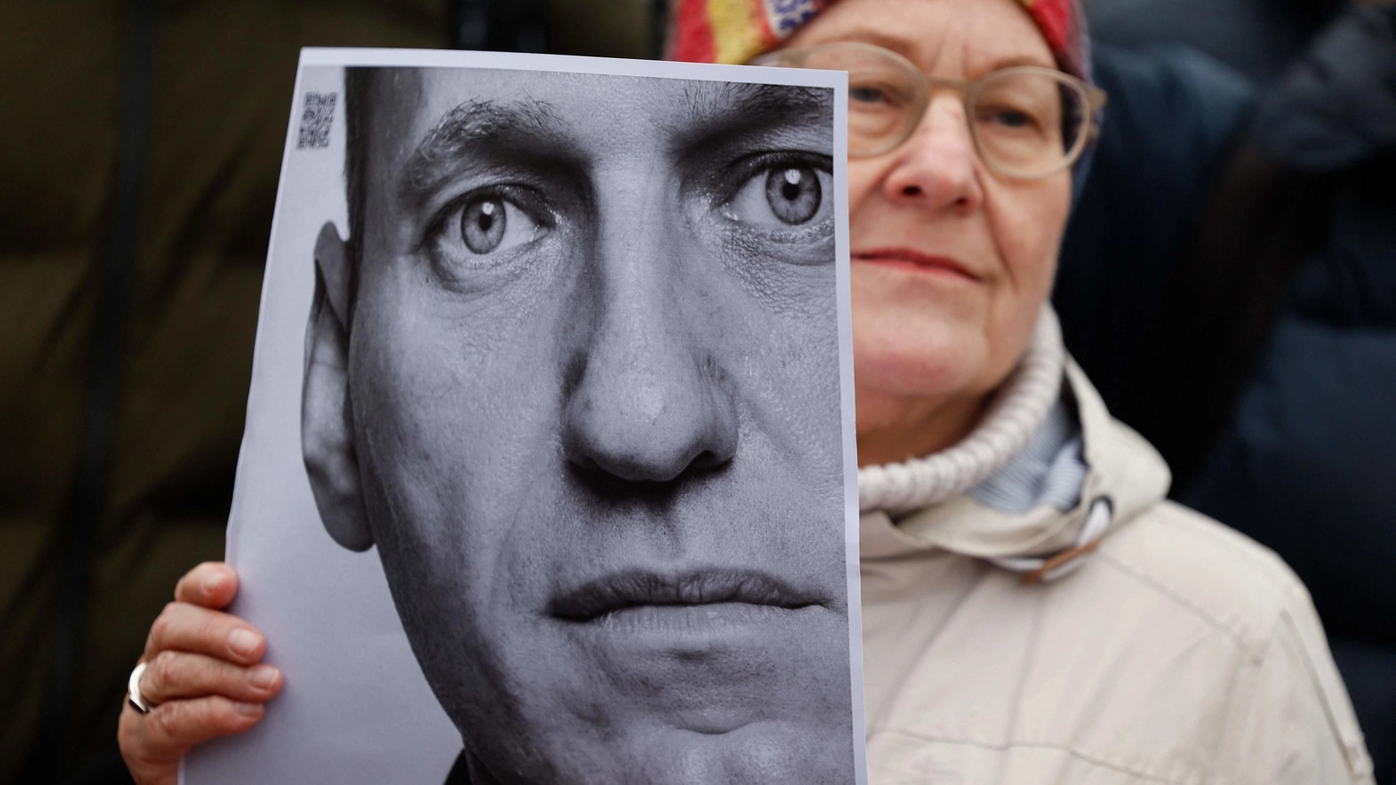 Una donna a Berlino mostra la foto di Navalny davanti all'ambasciata russa (Ansa)