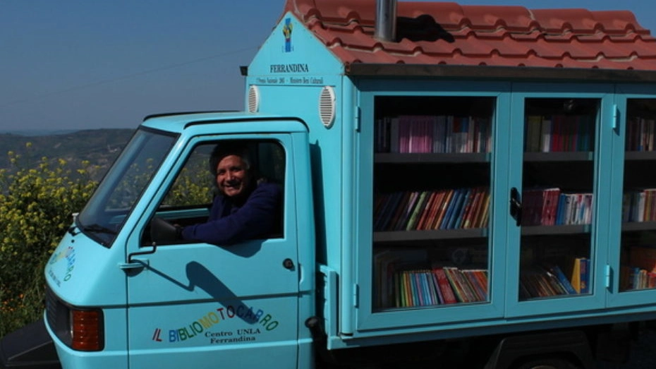 Il maestro Antonio La Cava, 74 anni, sul suo 'bibliomotocarro' realizzato con un’Apecar