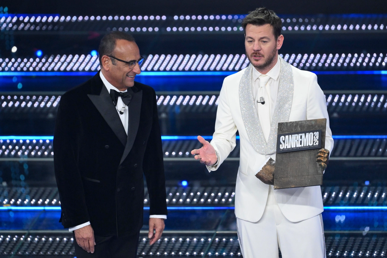 Alessandro Cattelan consegna  un reperto della statua del dopo festival a Carlo Conti