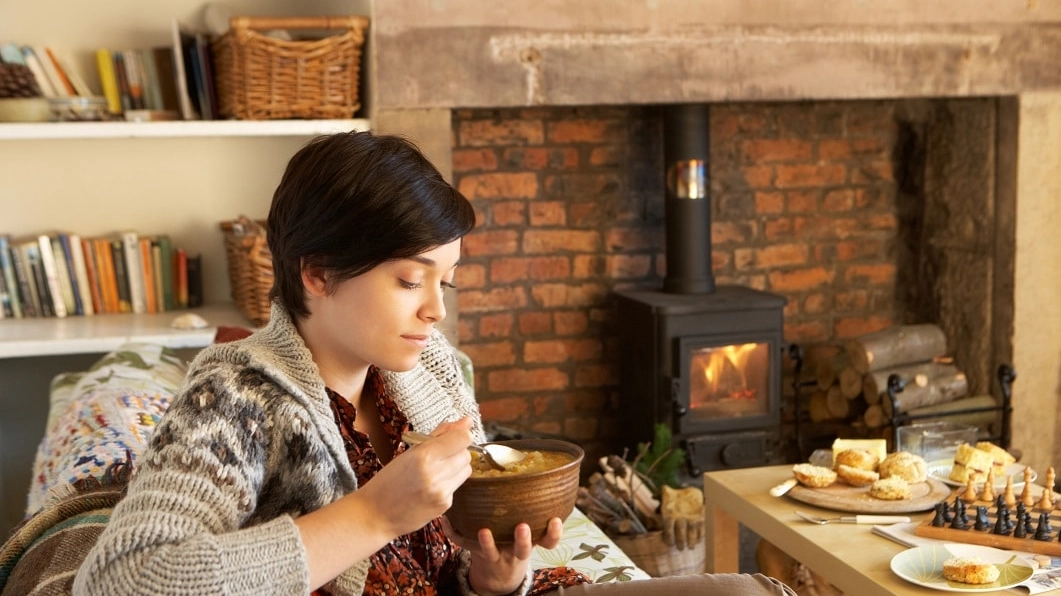 Young woman eating by fire