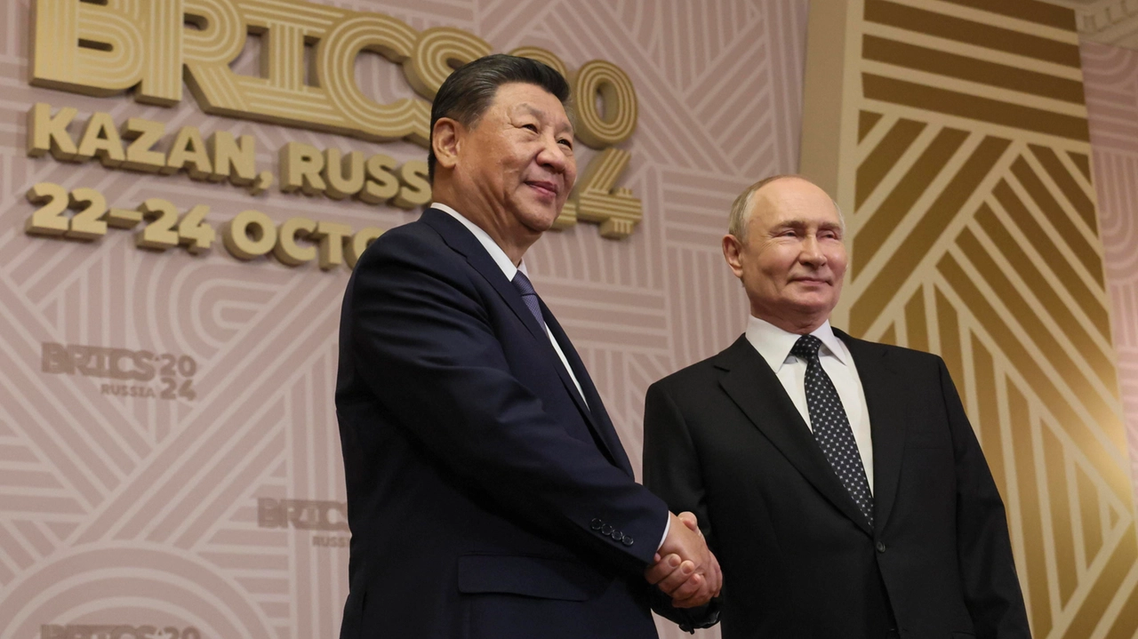 Stretta di mano tra Vladimir Putin e Xi Jinping alla cerimonia di apertura del summit dei Brics (Ansa)