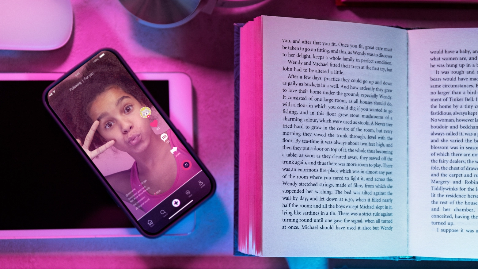 L'app di TikTok aperta sullo smartphone accanto a un libro