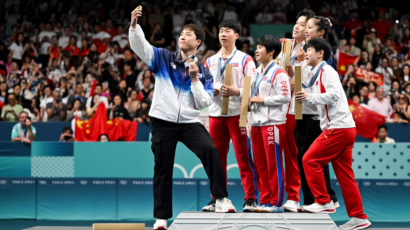 L'atleta sudcoreano Lim Jong-hoon (sinistra) scatta un selfie con gli avversari nordcoreani Ri Jong Sik e Kim Kum Yong (al centro) e la squadra cinese (destra) (AFP)