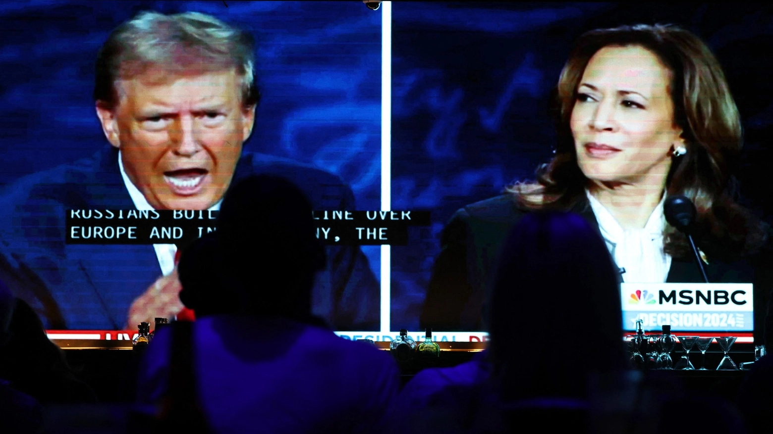 Gli americani guardano il dibattito tra Donald Trump e Kamala Harris sugli schermi televisivi (Ansa)