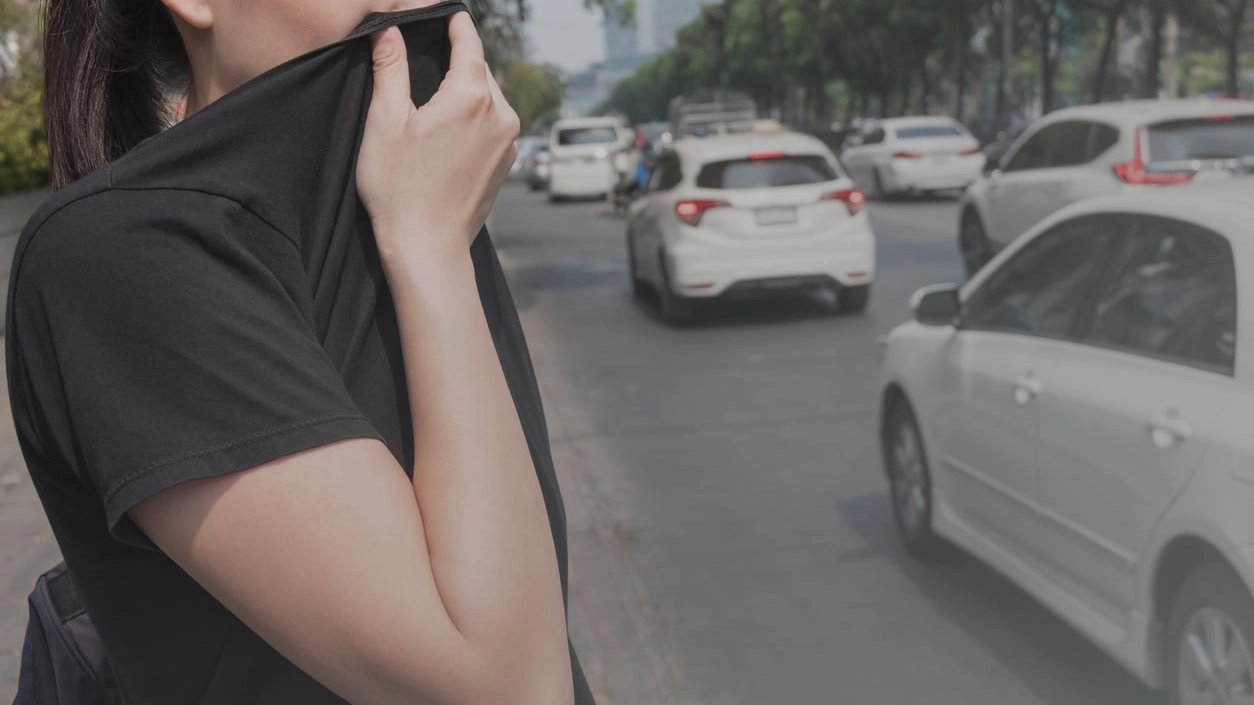 woman closes her nose with hand because of bad traffic pollution