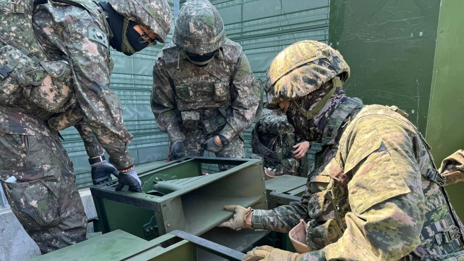 Dei soldati sudcoreani preparano uno degli altoparlanti messi lungo la linea di confine (ANSA)