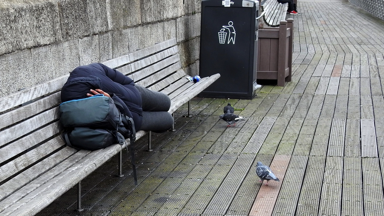 Un uomo dorme su una panchina