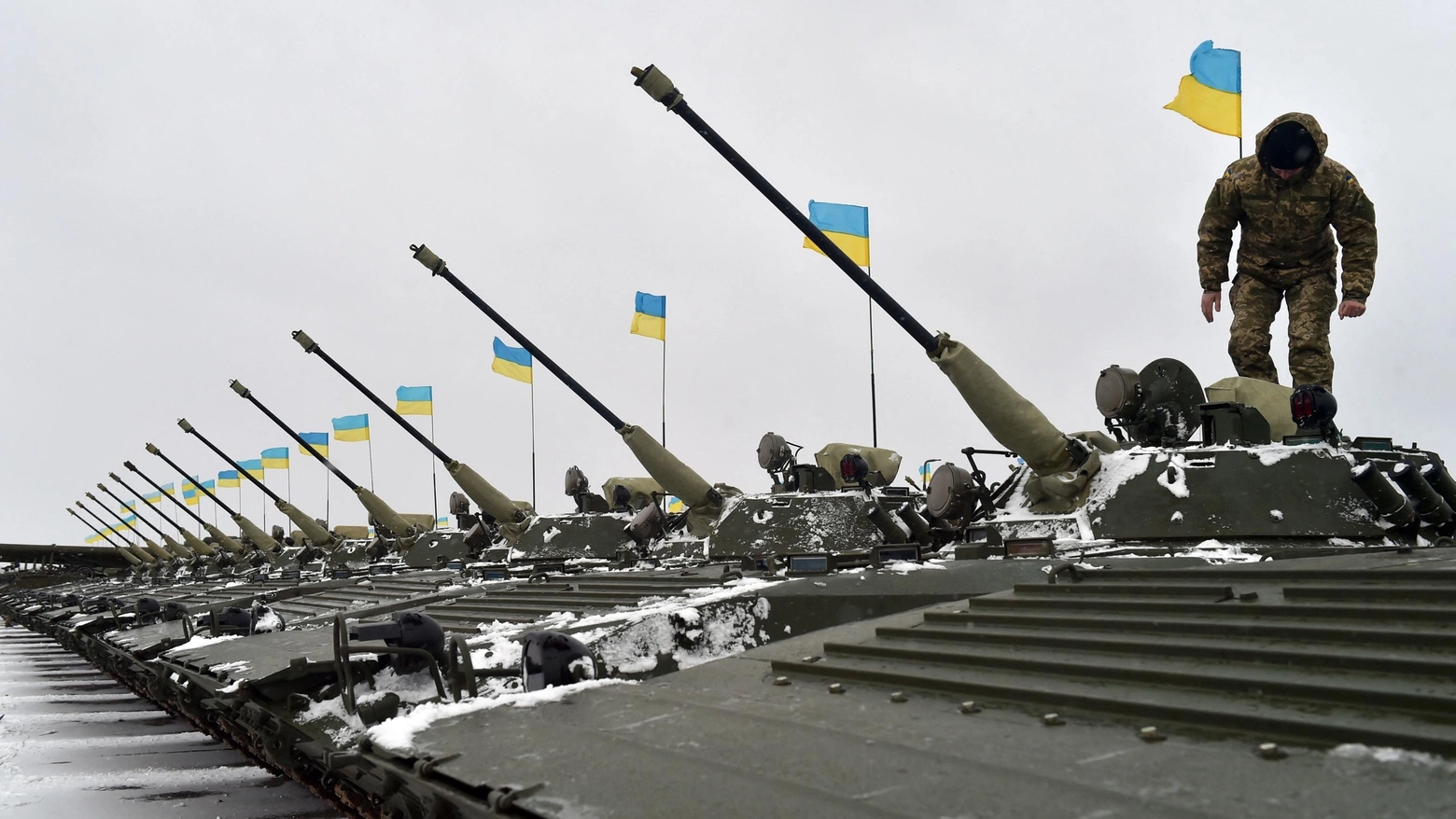 Ucraina, un soldato cammina su nuovi carri armati consegnati per la guerra (Ansa)