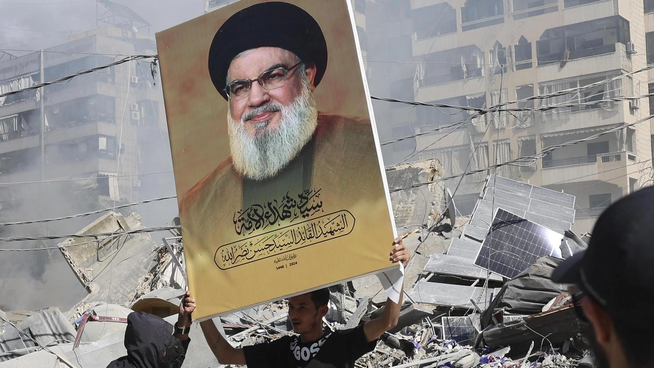 Tra le macerie di Beirut un uomo inneggia a Nasrallah, leader defunto di Hezbollah