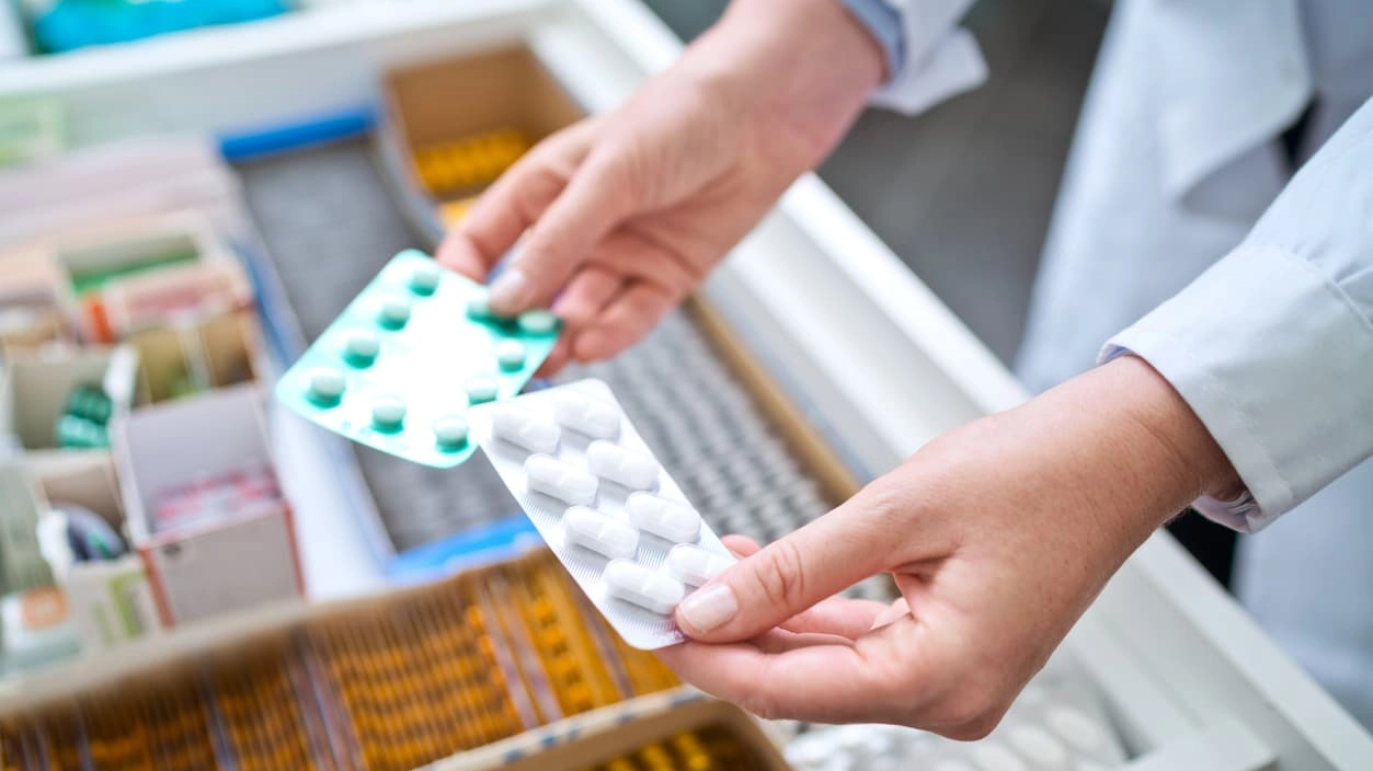 Female pharmacist holding medicines