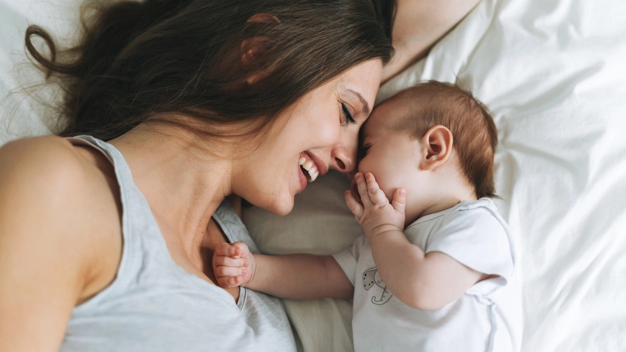 Young mother having fun with cute baby girl on bed, natural tones, love emotion