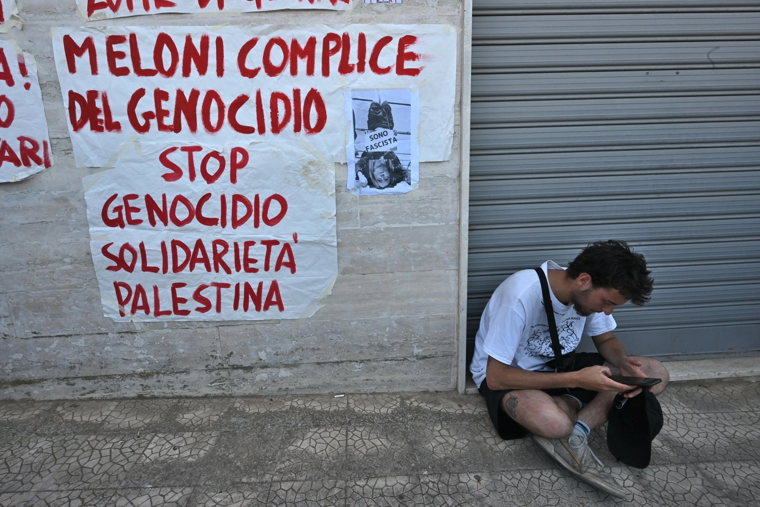 Una foto della premier italiana a testa in giù con la scritta "Io sono fascista" è stata affissa sui muri di largo Palmina Martinelli a Fasano dove si sono dati appuntamento i manifestanti del coordinamento No G7 (Ansa)
