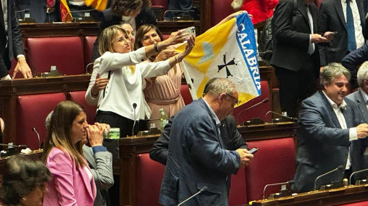 Simona Loizzo espone alla Camera una bandiera della regione Calabria per celebrare l’approvazione dell’autonomia differenziata, meglio nota come lo “Spacca Italia” (Ansa)