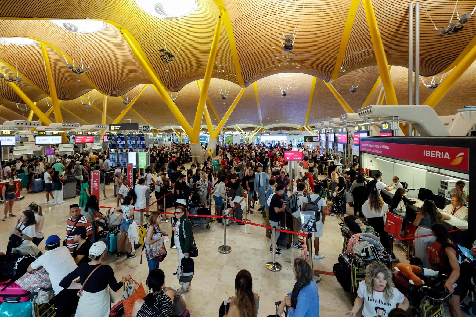 Passeggeri in attesa all'aeroporto di Madrid (Ansa)