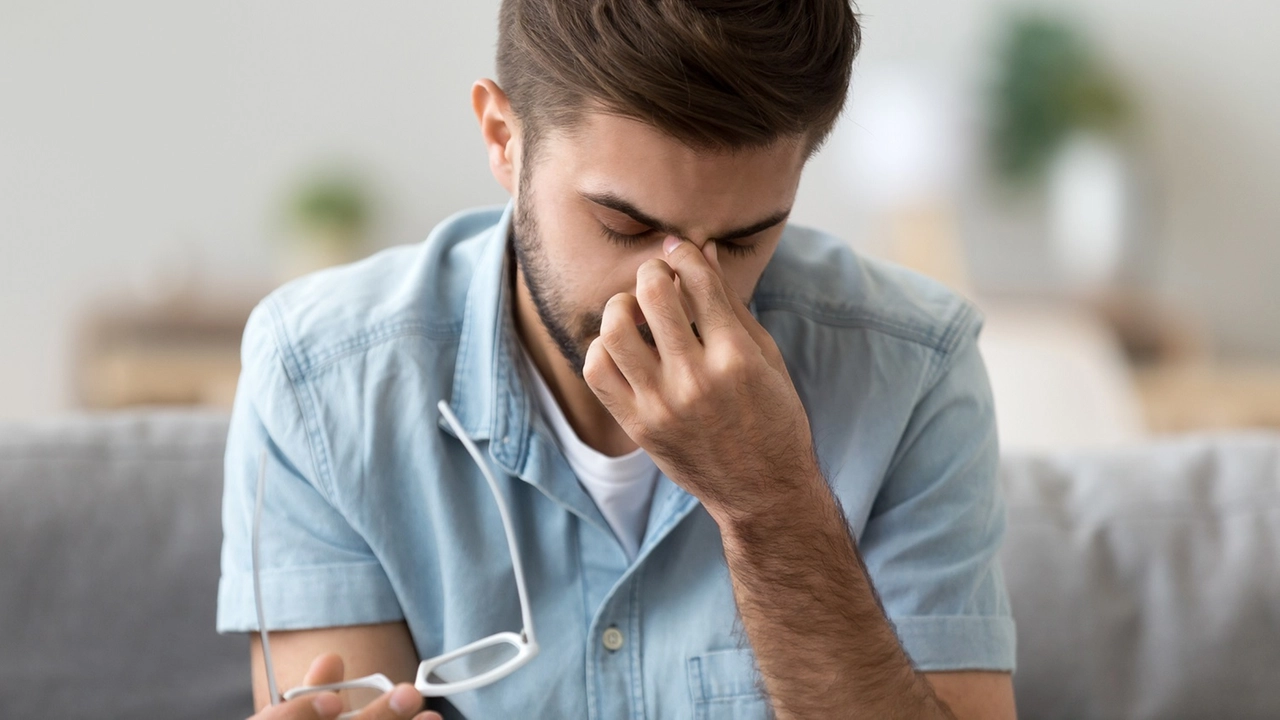 Close up man take off glasses, suffering from dry eyes syndrome