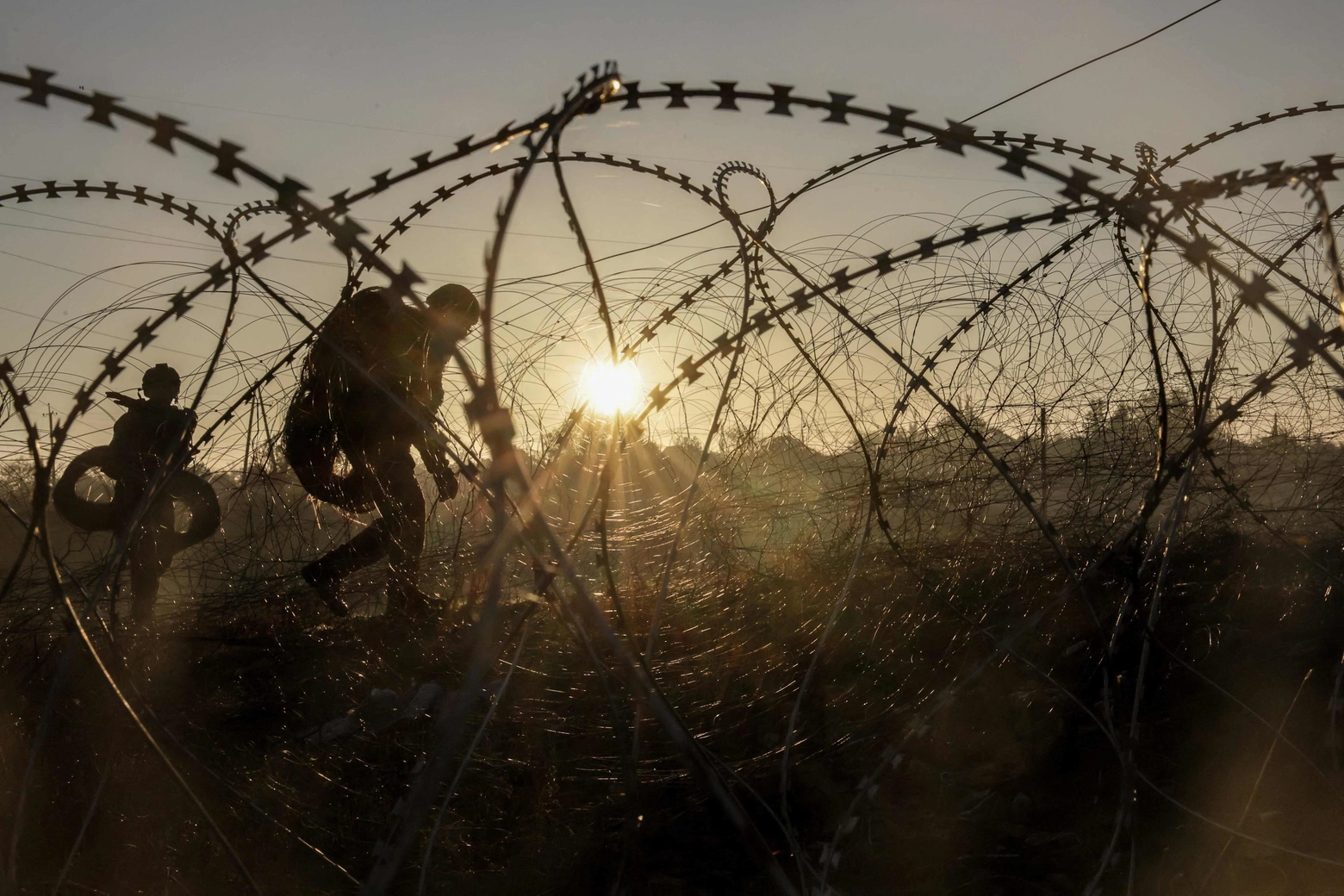 Soldati ucraini all'alba passano il filo spinato e piazzano le mine davanti al fronte nel Donetsk