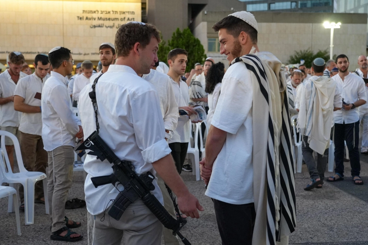 Celebrazioni blindate per lo Yom Kippur: un uomo armato durante la preghiera della sera a Tel Aviv (Ansa)