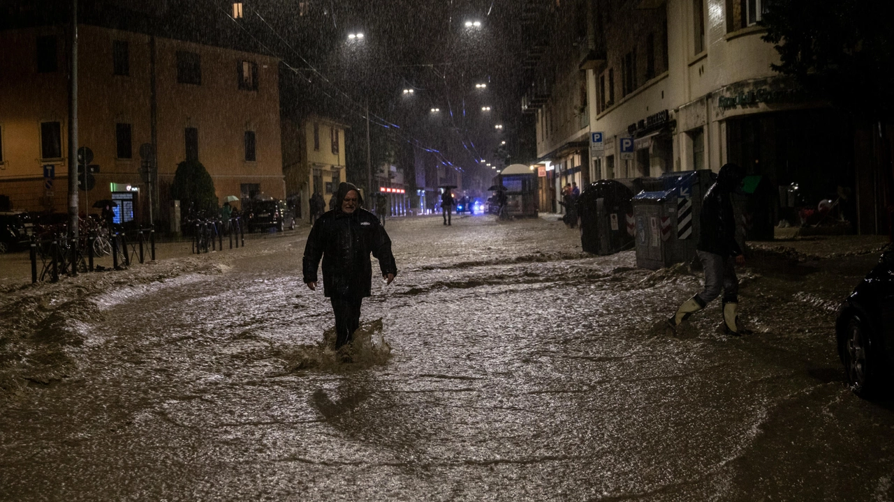 Un uomo in strada durante l'ultima alluvione a Bologna (foto Ansa)