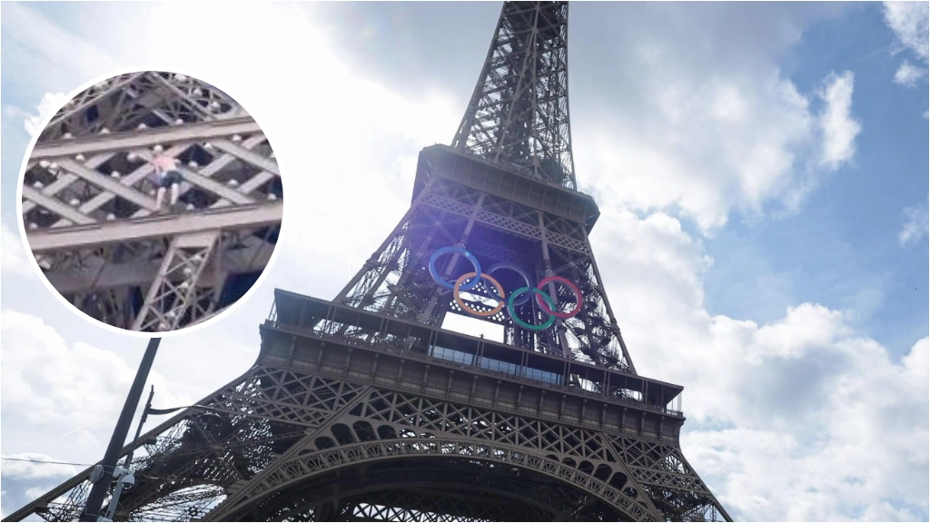 Un uomo a torso nudo si arrampica al secondo piano della Torre Eiffel