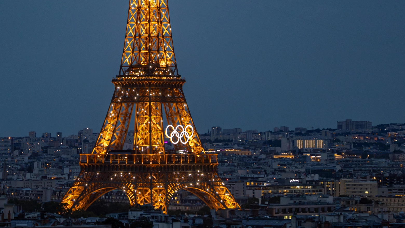 Una veduta notturna della Torre Eiffel con i cinque cerchi olimpici (Ansa)