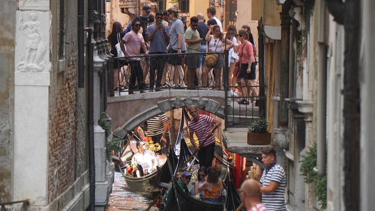 Gondole e turisti su un canale interno del centro storico di Venezia