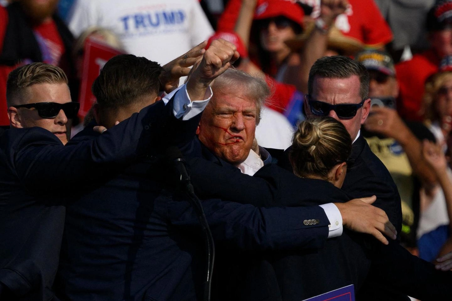 Donald Trump (78 anni) alza il pugno mentre viene portato via dai Servizi segreti dopo gli spari