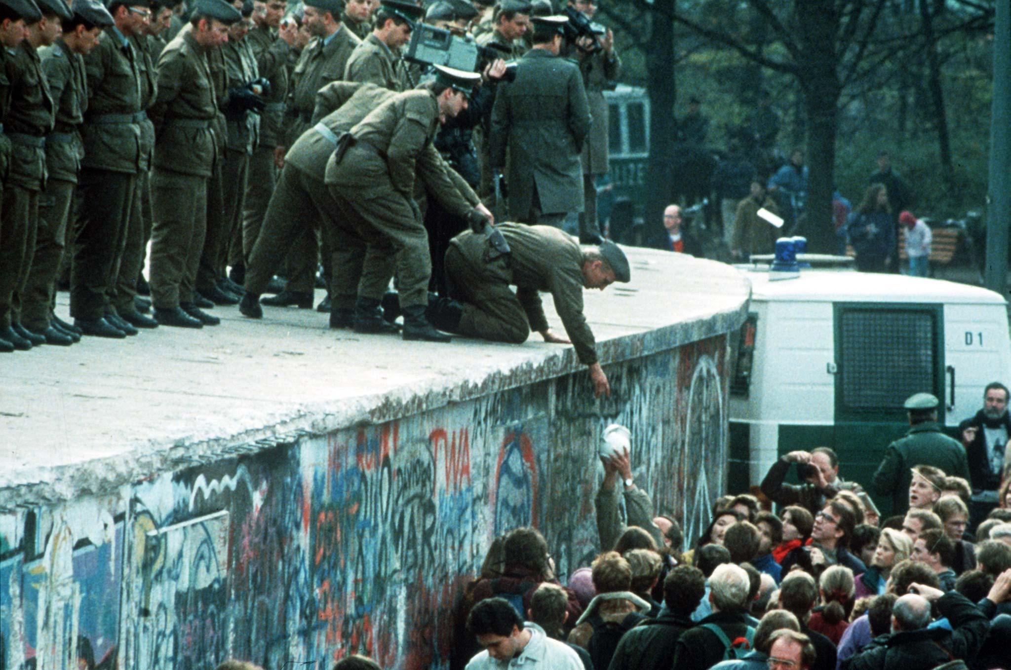 Il muro di Berlino cadeva 35 anni fa. La frase in diretta, la piccola folla che diventa oceano e quell’abbraccio infinito