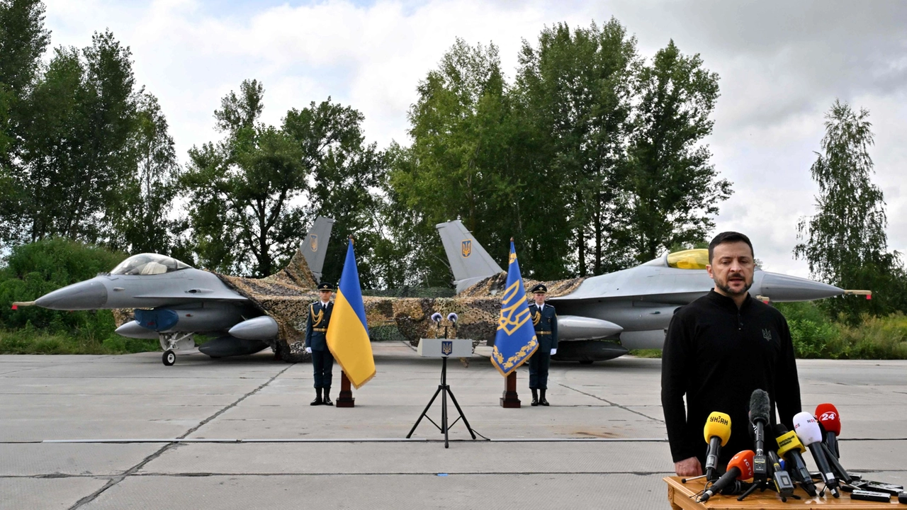 Volodymyr Zelensky posa davanti a due caccia F-16 (foto Ansa)