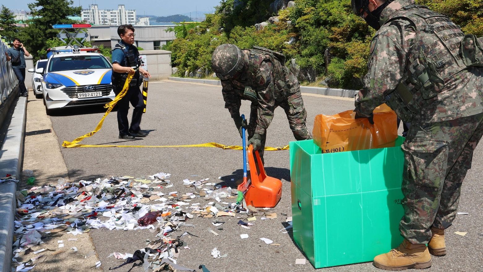I militari ripuliscono l'immondizia portata dai palloncini