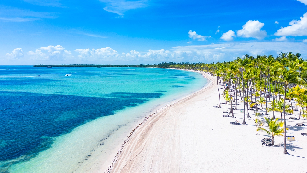 Vista aerea della splendida spiaggia di Bávaro, con sabbia bianca e palme. Acque turchesi e cielo azzurro a Punta Cana