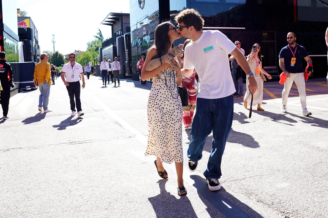 Imola, un bacio romantico tra Charles Leclerc e la fidanzata Alexandra che tiene in braccio il cucciolo Leo