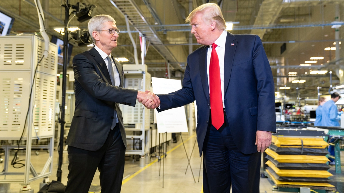 Donald Trump stringe la mano al Ceo di Apple, Tim Cook, durante la visita a uno stabilimento nel 2019