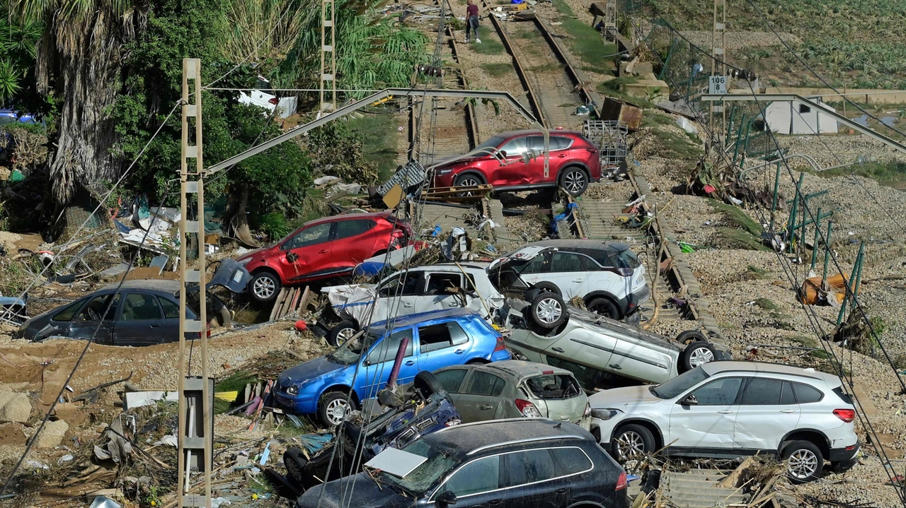 Le auto sulla ferrovia ad Alfafar, nella regione di Valencia, colpita dall'alluvione (foto Ansa)