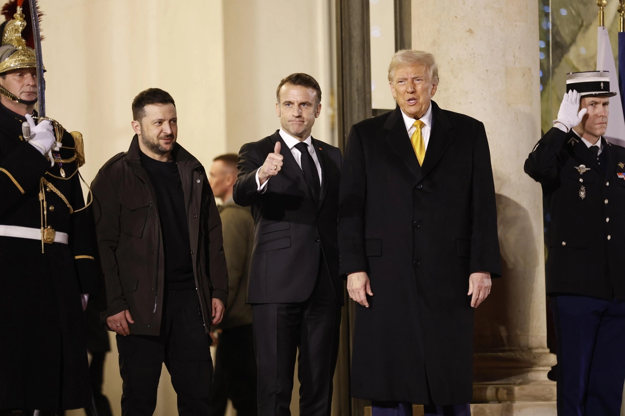 Il presidente francese Emmanuel Macron fa il gesto del pollice alzato verso i fotografi alla fine dell'incontro trilaterale con il presidente Usa eletto Donald Trump e il presidente ucraino Volodymyr Zelensky