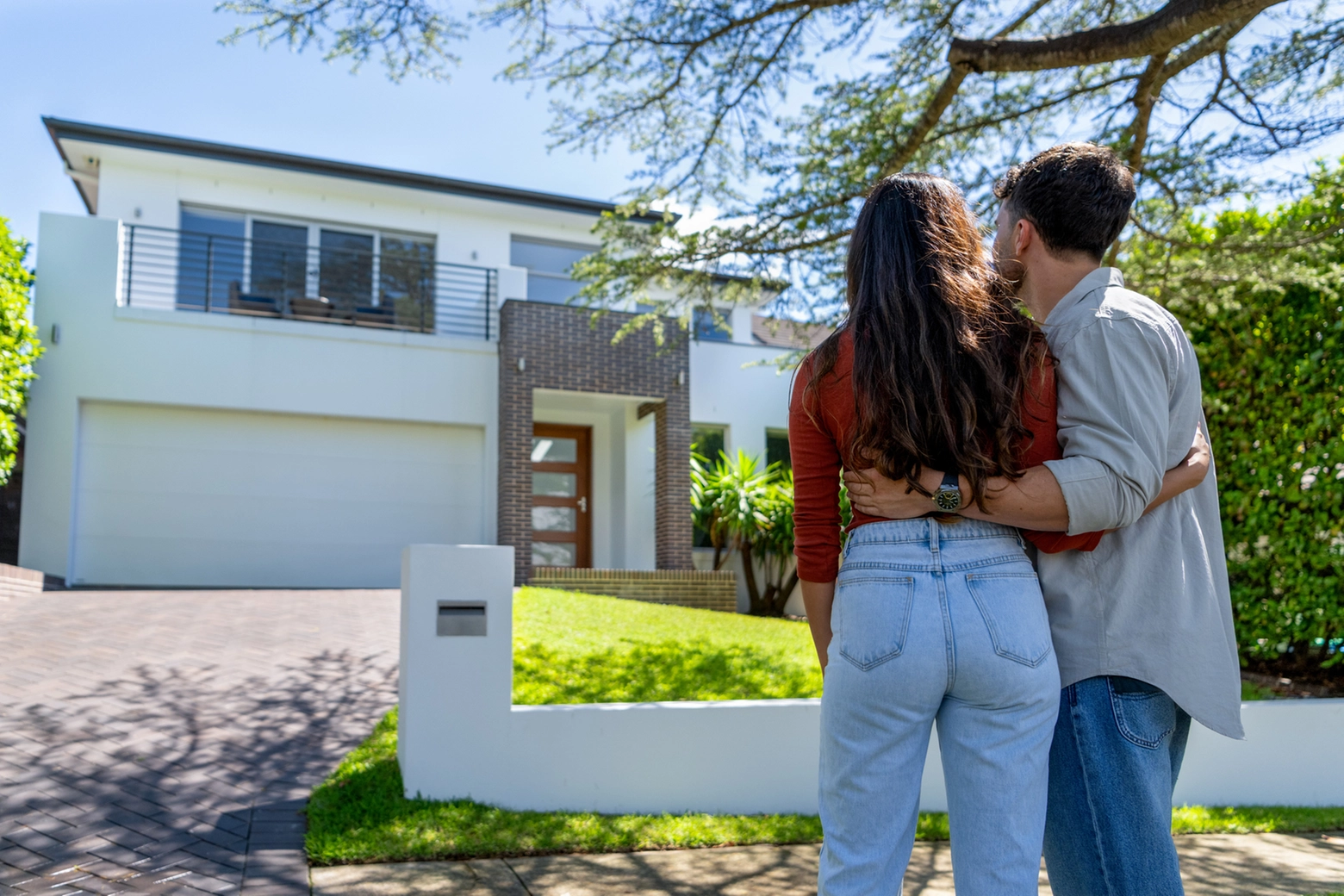 Una giovane coppia davanti a una casa, foto generica